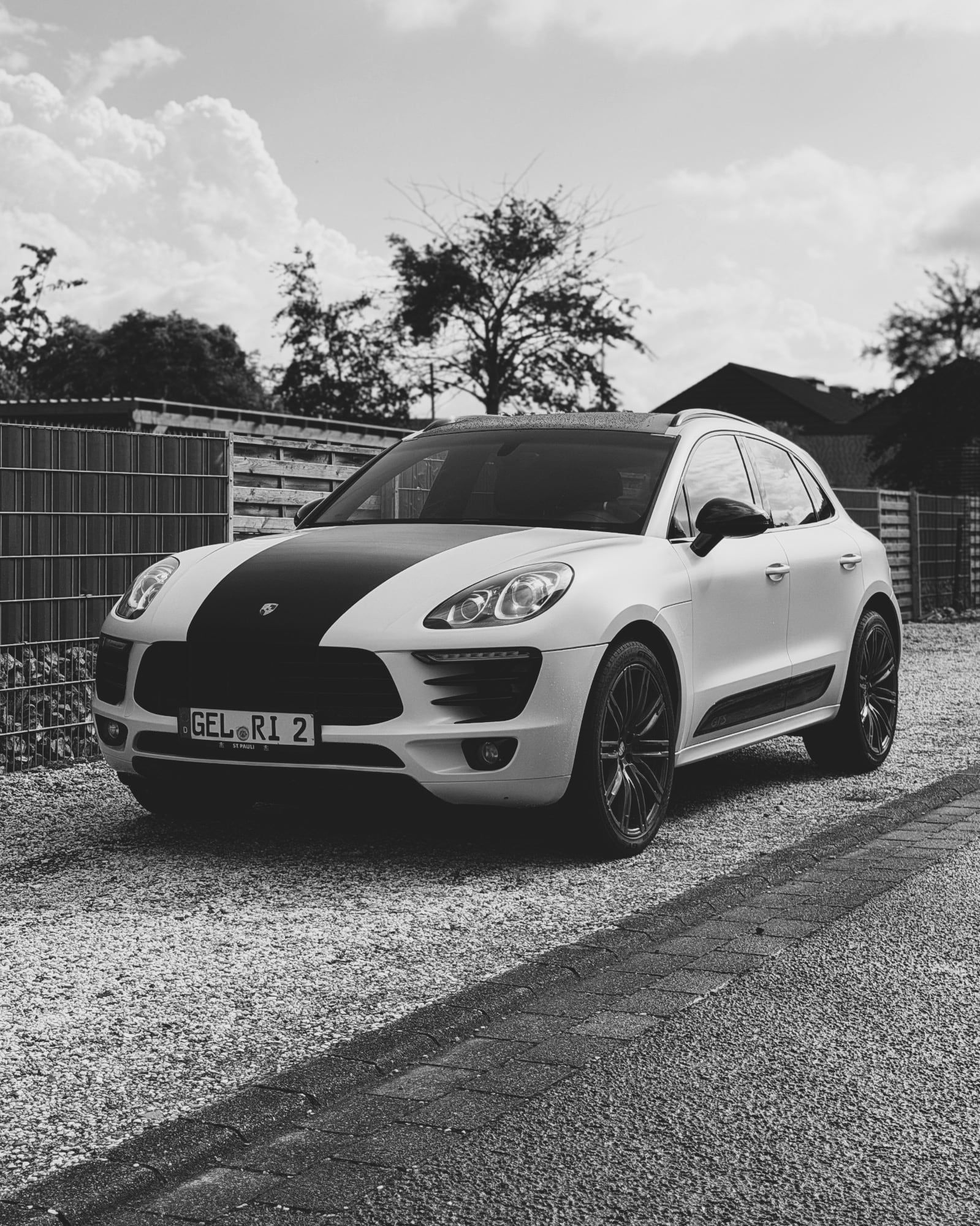 Weißer Porsche Macan mit schwarzen Designstreifen und roten Felgen, foliert von STUDIO ONE